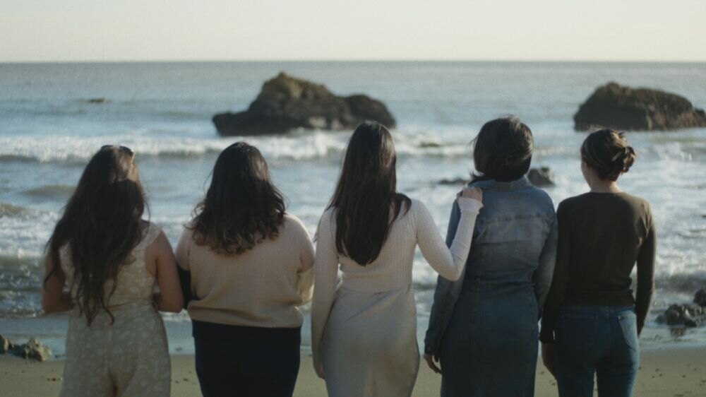 Ženské oběti Naasóna Joaquína Garcíi stojící zády k objektivu, se dívají na moře.
