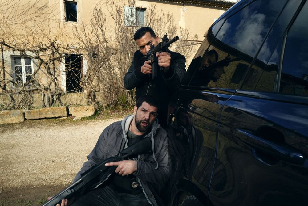 Mír v Marseille (Blood Coast). Muži se zbraněmi schovávající se za autem.